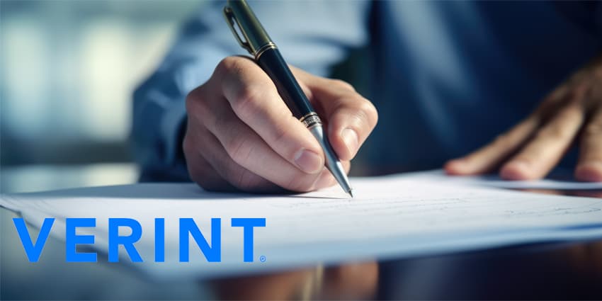 Close-up of a person's hand holding a pen and signing a document, suggesting a business or legal agreement.