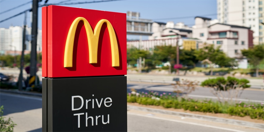McDonald's logo and drive thru sign at the entrance of McDonald's building