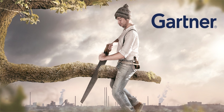 Man cutting branch that he's sitting on