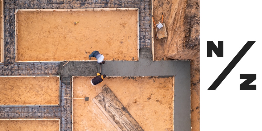 Workers leveling poured liquid concrete or cement on steel reinforcement, building foundation construction in process, aerial top view.