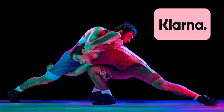 Two young athlete man, skilled wrestlers in red and blue uniform wrestling in motion against black background in mixed neon lights. Concept of motion,